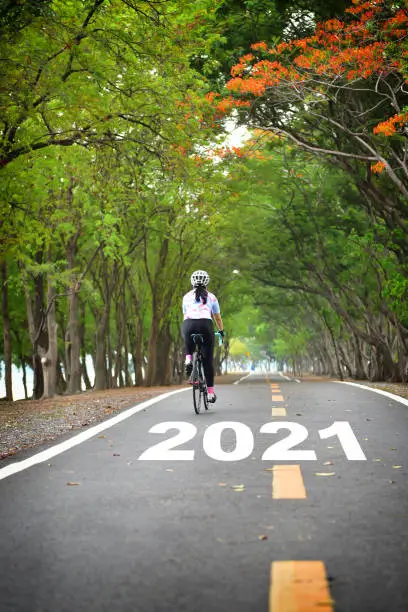 Photo of New year 2021 and sportswoman ride bike on road