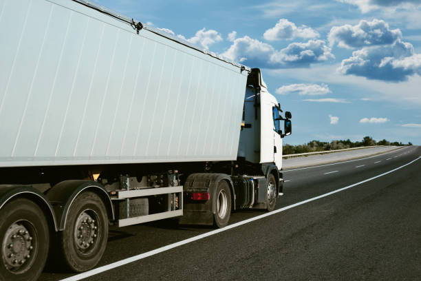 istock truck is on the road, side view, empty space on a white container - concept of cargo transportation, trucking industry 1265180777
