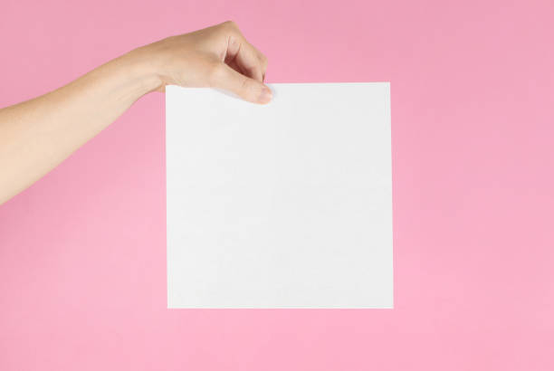 istock Hand holding up a blank sign, isolated against a pink background. 1265180789
