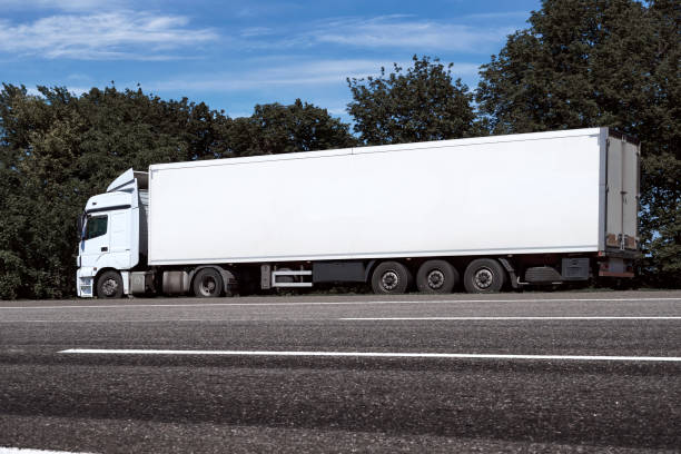 istock truck on the road, side view, empty space on a white container - concept of cargo transportation, trucking industry 1265180825