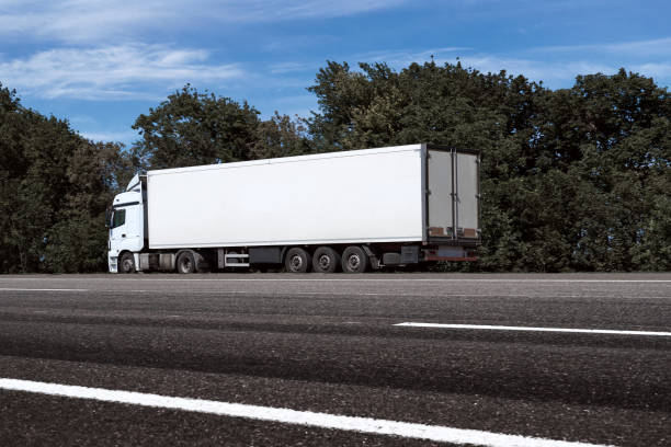 istock truck on the road, side view, empty space on a white container - concept of cargo transportation, trucking industry 1265180839
