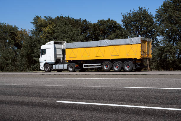 istock truck on the road, side view, empty space on a yellow container - concept of cargo transportation, trucking industry 1265180847