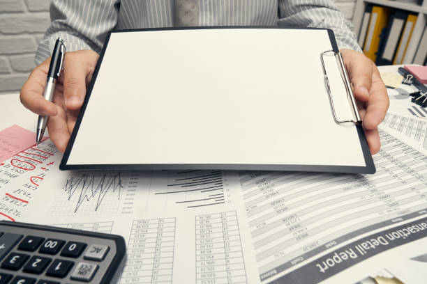 istock Business analysis and accounting concept - businessman working with document, spreadsheet, using calculator, tablet pc. Office desk closeup. 1265181263