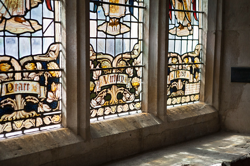 Detail of sunlight through the lower part of a stained glass window in an English church