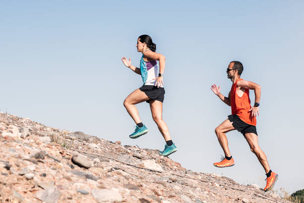 istock Healthy young couple running on mountain trail. 1265183545