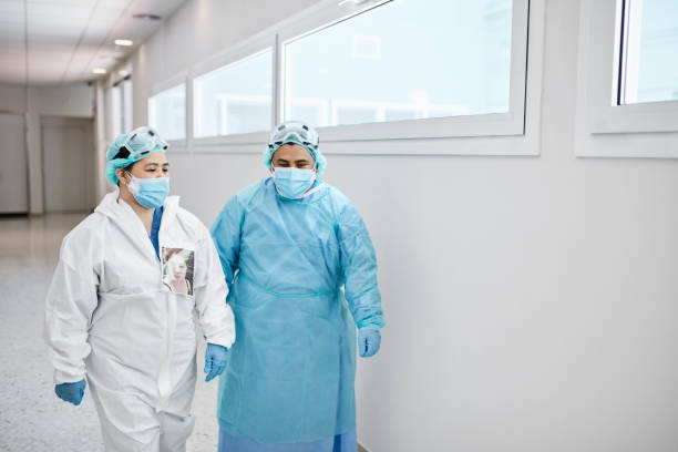 istock Tired Medical Professionals Walking in Corridor During COVID-19 1265185341