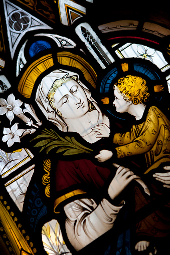 Virgin Mary holding baby Jesus depicted in a stained glass window in an English church