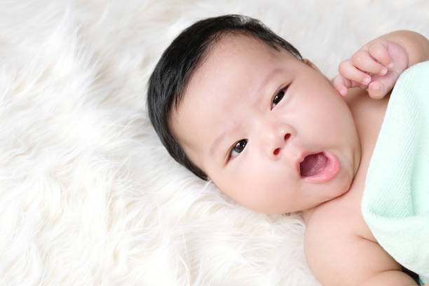 крупным планом младенца, спящего на белом фоне. - baby yawning asian ethnicity newborn стоковые фото и изображения