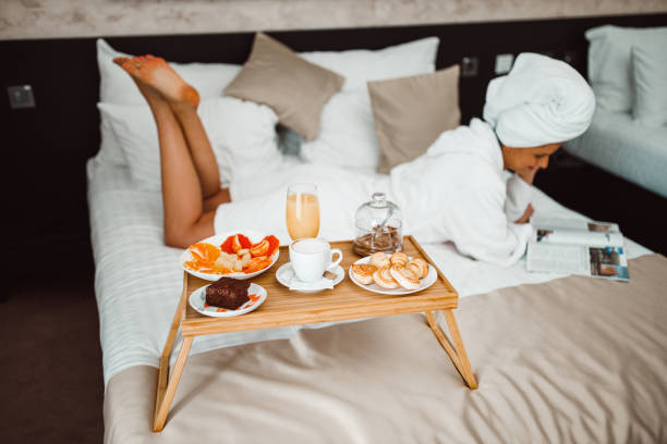 istock Woman eating breakfast in bed and reading a magazine 1265191067