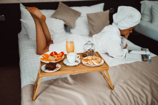 istock Woman eating breakfast in bed and reading a magazine 1265191087