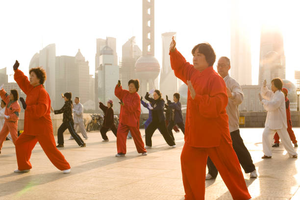 People practicing Tai Chi in Shanghai The Bund, Shanghai, China, Asia - November 17, 2008: People practicing Tai Chi at sunrise at the riverside of the Huangpu river with Pudong skyline in the background. promenade shanghai stock pictures, royalty-free photos & images