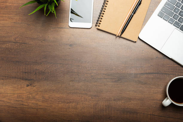 Flat lay of Office desk wooden table with laptop, and smartphone and equipment other office supplies Flat lay of Office desk wooden table with laptop, and smartphone and equipment other office supplies with copy space, top view above stock pictures, royalty-free photos & images