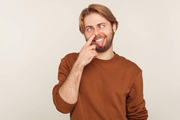 verticale de l’homme comique muet avec la barbe dans le nez de cueillette de sweat-shirt, regardant le regard croisé avec l’expression stupide - cross eyed photos photos et images de collection