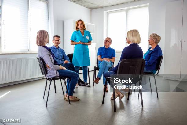 Nurse During Meeting With Senior People In Nursing Home Stock Photo - Download Image Now