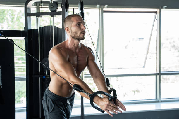 istock Muscular bodybuilder handsome men doing cable fly exercises in gym with naked torso. Strong athletic guy with abdominal muscles and biceps. 1265193938