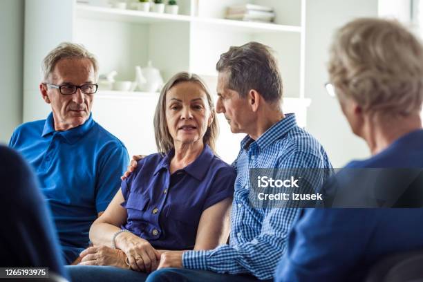 Senior Couple Sharing Issues During Meeting Stock Photo - Download Image Now - Embracing, Group Therapy, 70-79 Years