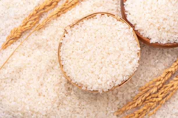 istock Raw rice in a bowl and full frame in the white background table, top view overhead shot, close up 1265193978