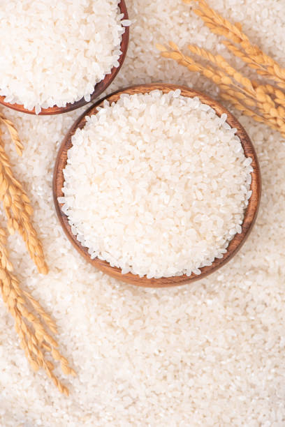 istock Raw rice in a bowl and full frame in the white background table, top view overhead shot, close up 1265193993