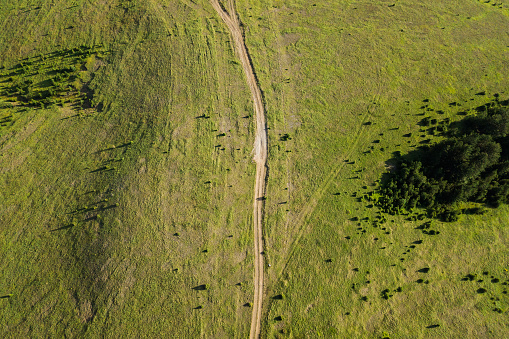Aerial view of a dirt road going through mountain planes