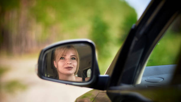 istock Reflection of woman in rear-view mirror 1265195075