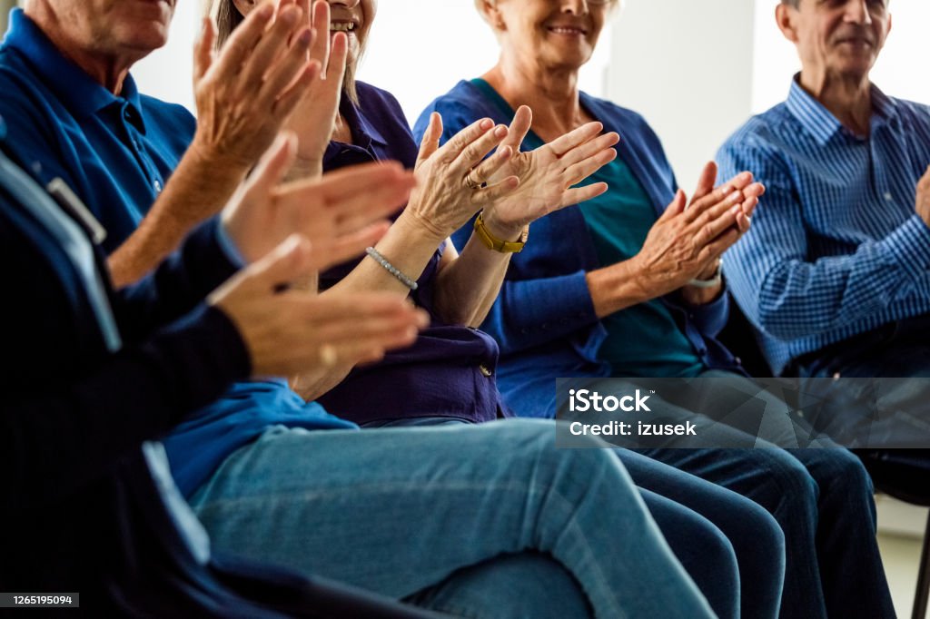 Senior people clapping hands during meeting Senior people sharing his issues with patients during group therapy in nursing home. They are discussing about mental wellbeing, clapping hands. Close up of hands, unrecognizable people. Group Therapy Stock Photo