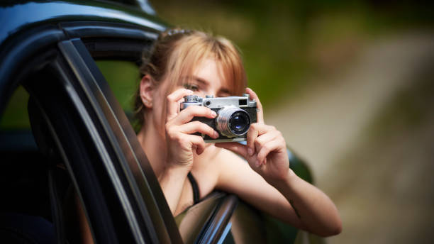 istock Young woman using a camera during a road trip 1265195150
