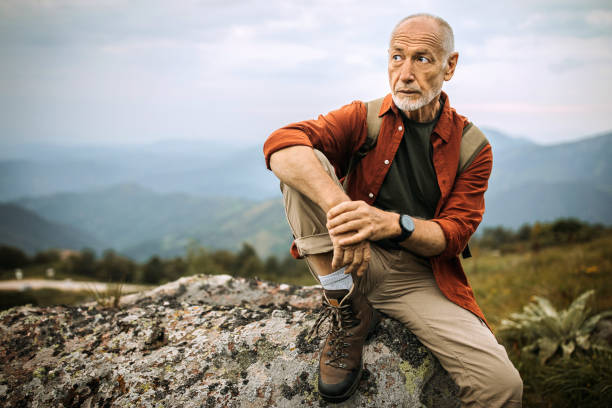 istock Senior hiker taking rest on the rock 1265195369