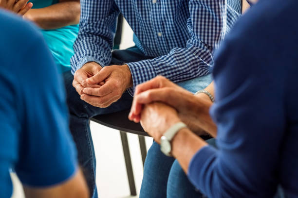 Senior people during meeting, close up of hands Senior people sharing his issues with patients during group therapy in nursing home. Close up of hands, unrecognizable people. group therapy photos stock pictures, royalty-free photos & images