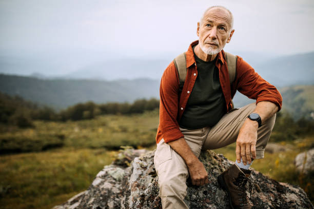 istock Senior hiker posing on the mountain rock 1265195441