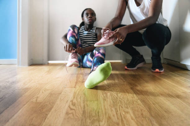 istock mother helping her daughter putting on running shoe 1265197135