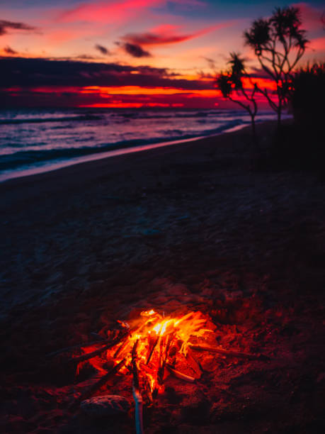istock Bonfire on beach with waves and bright sunset or sunrise in Bali. 1265197181