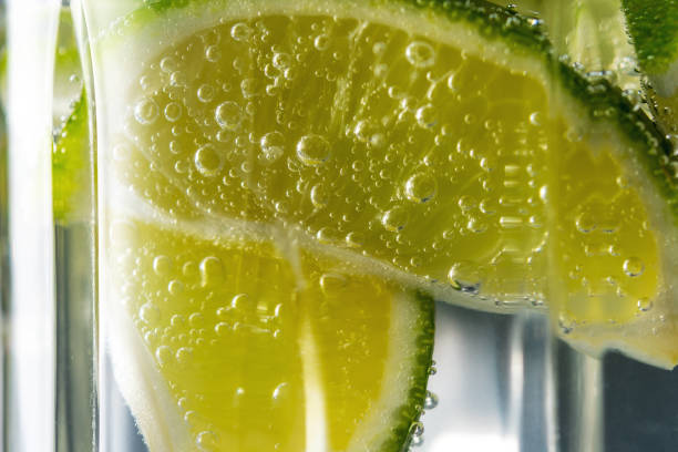 istock Lime slice with a drops in fizzy sparkling water. Summer drink concept. 1265198453