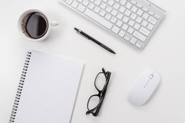 istock White office desk table with blank notebook, computer keyboard and other office supplies. Top view with copy space. 1265198494