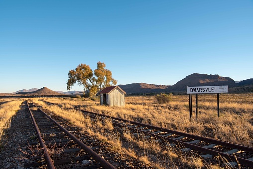 Railway lines with guest waiting station and karoo mountains in the distance