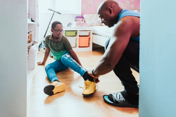 istock father helping his son putting on soccer shoe 1265199922