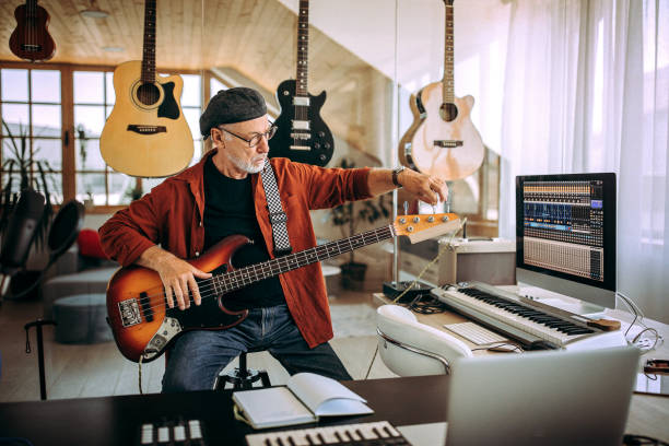 istock Senior rock guitarist tuning guitar in his home studio 1265201553