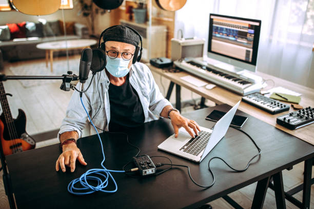 istock Senior radio host with face mask in his home office 1265201805