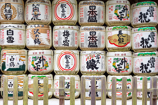 Nara, Japan - 13 June 2016: Traditional colourful barrels of sake with japanese signs atNara Park. Called kazaridaru, these are displayed outside of Shinto shrines.