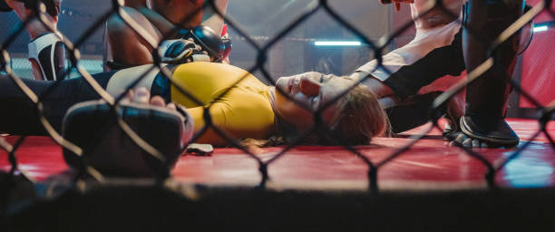istock Knockout during martial arts training. Helping unconcious woman 1265205691