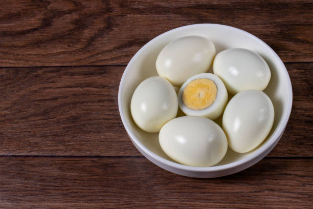 istock Boiled peeled eggs without shell on a wood brown background. 1265206025