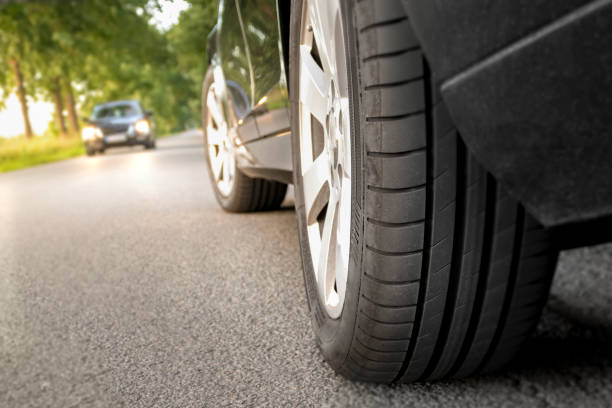 parked car on the country road with focus on the rear tires of the vehicle - two way traffic imagens e fotografias de stock