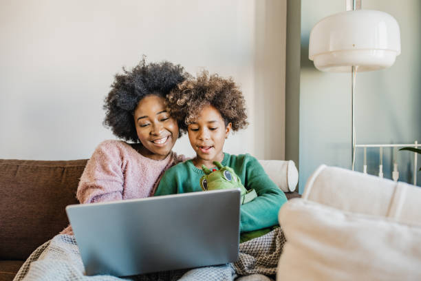 istock Young mother is using laptop at home with hers daughter 1265209058