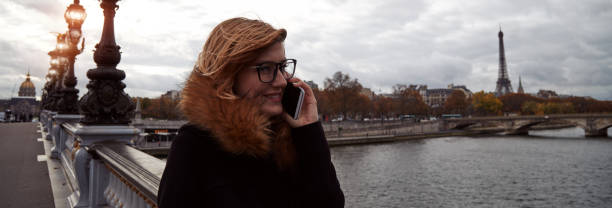 garota usando celular com fundo da cidade de paris, rio sena e torre eiffel. - seine net fotos - fotografias e filmes do acervo