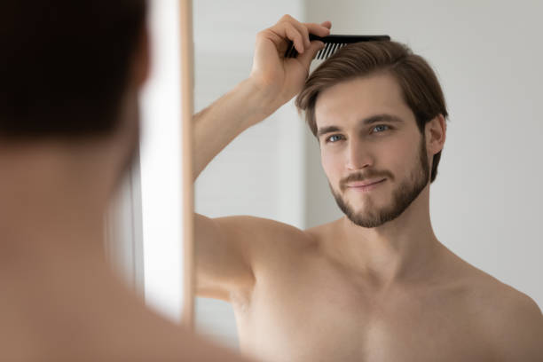 istock Close up mirror reflection handsome young man combing hair 1265210575