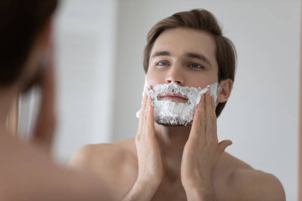 istock Mirror reflection close up young man applying shaving foam 1265210612