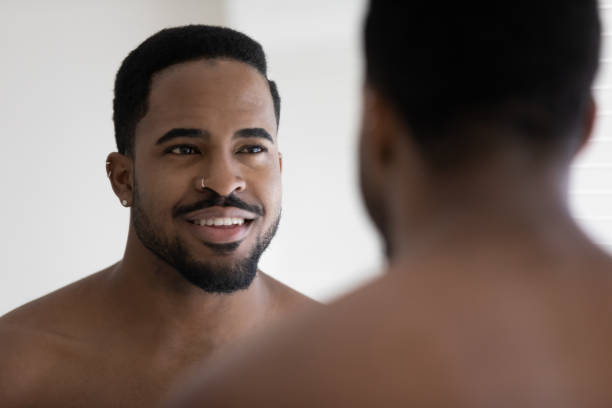 istock Close up handsome African American young man looking in mirror 1265210625