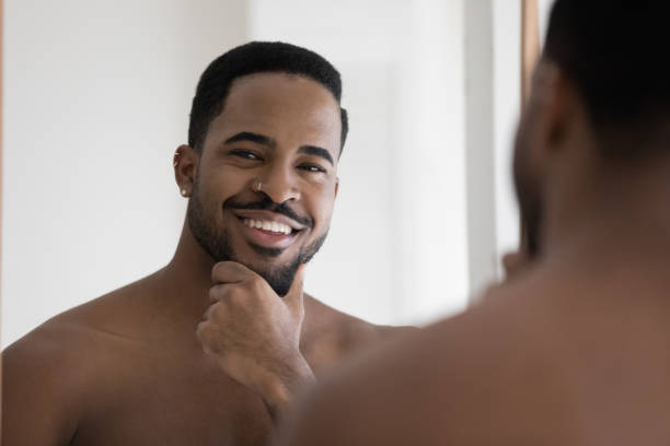 istock Head shot portrait smiling satisfied African American man touching beard 1265210630