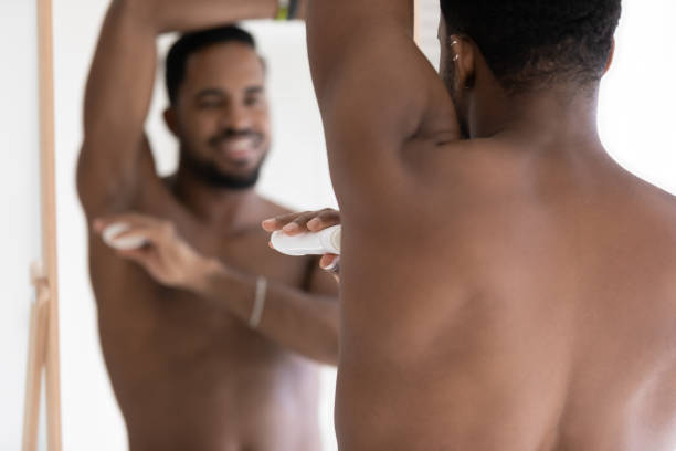 istock Rear view smiling African American man applying deodorant on armpit 1265210654
