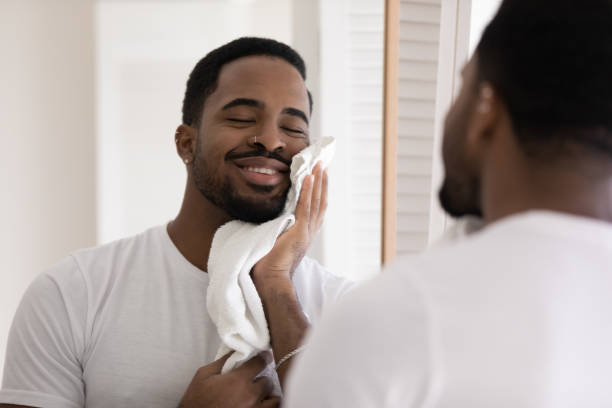 istock Mirror reflection satisfied African American man wiping face with towel 1265210670