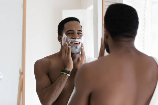 istock Mirror reflection smiling African American man applying shaving foam 1265210672